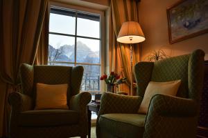 uma sala de estar com duas cadeiras e uma janela em Grandhotel Lienz Business-Wellness & Gourmet em Lienz