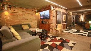 a living room with a couch and a brick wall at Apartament Fabryka Kobra in Bydgoszcz