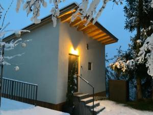 a house in the snow with a light on the door at Das Baumhaus in Völs am Schlern