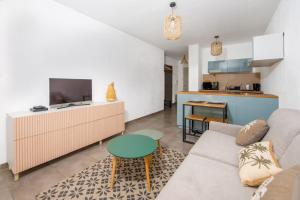 ein Wohnzimmer mit einem Sofa und einem Tisch in der Unterkunft Studio Port Golfe-Juan Parking Wifi Climatisation Terrasse in Vallauris