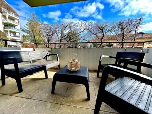 een groep banken en een tafel op een balkon bij Résidence aux portes de Genève in Annemasse