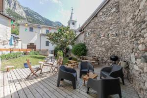 un patio con sedie, tavoli e un muro in pietra di Côté-Bourget 4 pers L'AIGUILLE DE SCOLETTE proche La Norma Aussois a Villarodin-Bourget