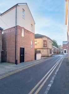 an empty street with a brick building on the side at Luton flat near town centre for Relocators, Tourists, Families in Luton