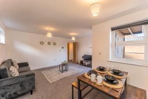 een woonkamer met een bank en een tafel bij Luton flat near town centre for Relocators, Tourists, Families in Luton