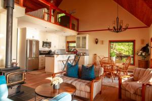 eine Küche und ein Wohnzimmer mit einer Couch und einem Tisch in der Unterkunft The Overlook, Luxury Lakeside Home with Dock in Harrison Hot Springs