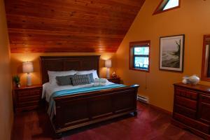 um quarto com uma cama e um tecto de madeira em The Overlook, Luxury Lakeside Home with Dock em Harrison Hot Springs