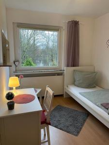 a bedroom with a bed and a desk and a window at Apartment First Floor Laatzen in Hannover
