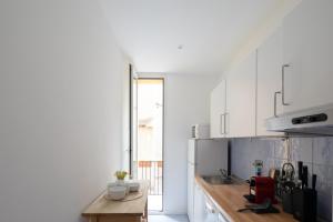 罗马Via Francesco Crispi Private Apartment的配有白色橱柜和木桌的厨房 更多17张照片