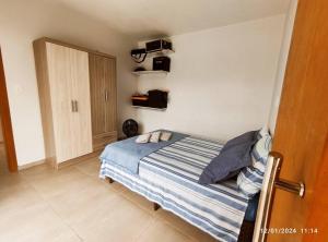 a bedroom with a bed with blue and white sheets at Quiosque com piscina e vista in Encantado
