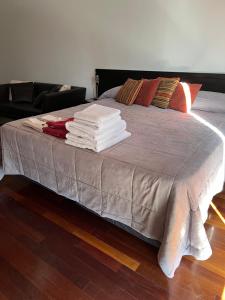 Una cama con una pila de mantas y almohadas. en Nice studio at Nicaragua 6042, en Buenos Aires
