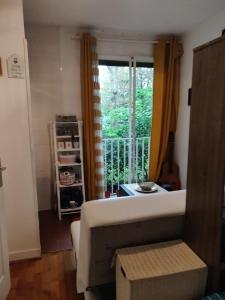 sala de estar con sofá y ventana en Cozy Gateaway, en Neuilly-sur-Seine