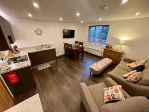 a living room with two couches and a kitchen and a table at Modern Bowness-on-Windermere Flat - Free Parking in Bowness-on-Windermere