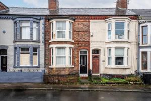 a brick house with a red door on a street at City Links-3Bdrm terraced House-Parking-Antonio st in Liverpool