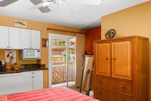 een keuken met een bed en een aanrecht bij Studio with mini kitchen, pool and BBQ, Pre-Renovation Summer Sale in Kihei