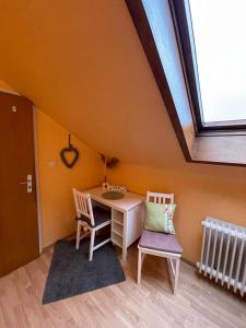 a desk and two chairs in a room with a window at Apartment First Floor Laatzen in Hannover