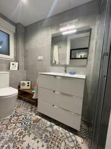 een badkamer met een wastafel, een toilet en een spiegel bij ALCOY-DENIA in Denia