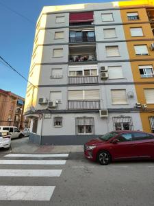 a red car parked in front of a building at ALCOY-DENIA in Denia