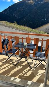 a table and chairs sitting on a balcony at Auron Joli appartement in Auron