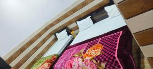 Una cama con una manta de colores encima. en K.D. Dham near Prem mandir, en Vrindāvan
