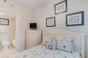a bedroom with a bed and a toilet and pictures on the wall at Sterling Shores in Destin