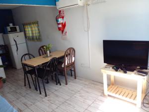 a kitchen with a table with chairs and a television at La Delia in Gualeguaychú