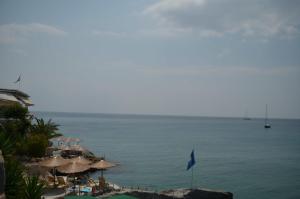 a view of a beach with umbrellas and the ocean at Panorama Hotel in Agia Marina Aegina