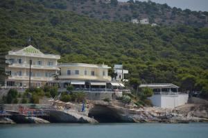 a large building on a hill next to the water at Panorama Hotel in Agia Marina Aegina