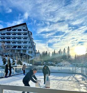 un groupe de personnes dans la neige avec des colis dans l'établissement Hotel Pestera, à Sinaia