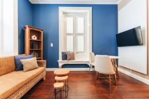 a living room with blue walls and a couch and a table at Atelier Skalo Boutique Hotel in Willemstad