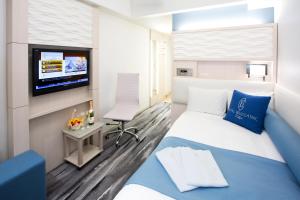 a hotel room with a bed and a tv at Hotel Bellclassic Tokyo in Tokyo