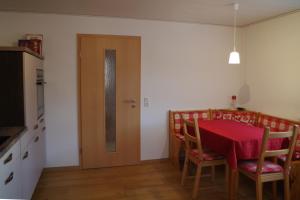uma sala de jantar com uma mesa e uma porta de madeira em Ferienwohnung Linde 