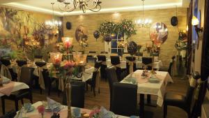 uma sala de jantar com mesas brancas, cadeiras e flores em The Little Britain Inn Themed Hotel One of a Kind In Europe em Vettelschoß