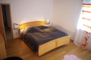 a bedroom with a bed with a wooden headboard at Ferienwohnung Linde 