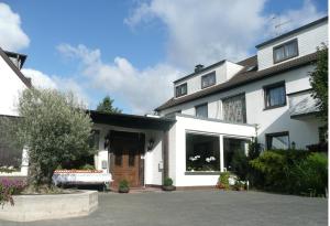 una casa blanca con una puerta delantera y un patio en Hotel Kölner Hof Refrath, en Bergisch Gladbach