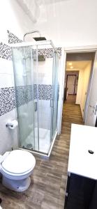 Un baño con inodoro y ducha de cristal. en Il centro di Ostia (apartment), en Lido di Ostia 12 fotos más