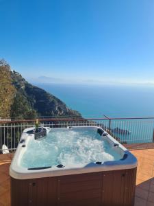 uma banheira de hidromassagem em cima de uma varanda em Villa il Dolce Tramonto em Furore
