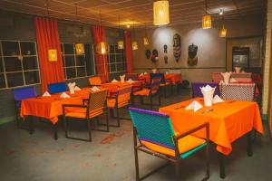 a dining room with orange tables and chairs at Room in Guest room - Isange Paradise Resort in Ruhengeri