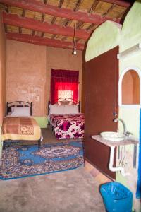 a bedroom with two beds and a sink in it at Kasbah Omari in Tinerhir