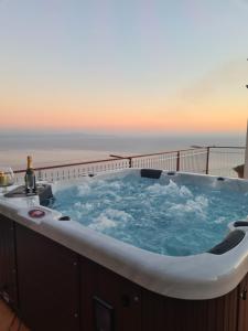 wanna z hydromasażem na balkonie z widokiem na ocean w tle w obiekcie Villa il Dolce Tramonto w mieście Furore