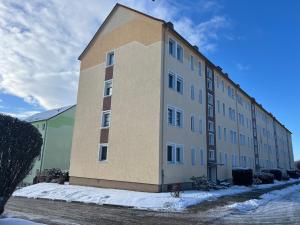 a large building with snow on the side of it at Studio Apartment Frühauf Geithain in Geithain