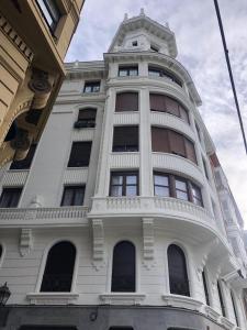 un edificio blanco con una torre encima en Apartamento en el mismo corazón del Casco Viejo, en Bilbao
