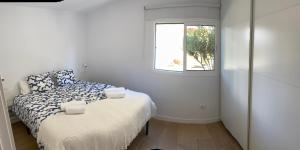 a small bedroom with a bed and a window at Las olas 214 in Maspalomas