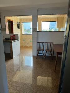 cocina y comedor con mesa y sillas en Belíssima Cobertura em IRIRI 4 andar inteiro do Prédio 2 Varanda en Anchieta