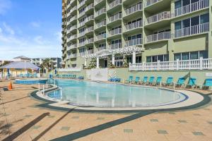 a swimming pool in front of a large apartment building at Boardwalk Beach Resort by Panhandle Getaways in Panama City Beach