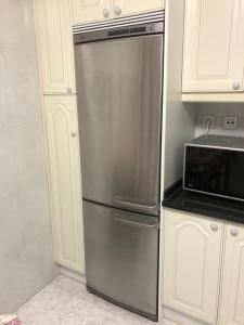 um frigorífico de aço inoxidável numa cozinha ao lado de um micro-ondas em Apartamento en el mismo corazón del Casco Viejo em Bilbao