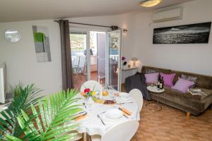 ein Wohnzimmer mit einem Tisch und einem Sofa in der Unterkunft Lumare in Grebaštica