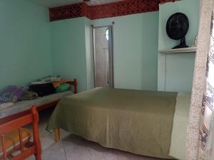 Schlafzimmer mit einem Bett und einem Fenster in der Unterkunft Família Souza in Cabo Frio