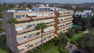 einem Luftblick auf ein Gebäude mit Palmen in der Unterkunft Fantastico Duplex Familiar Dunas Artola in Marbella