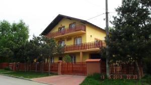 une maison jaune avec une clôture devant elle dans l'établissement AGAWA NOCLEGI, à Tarnów