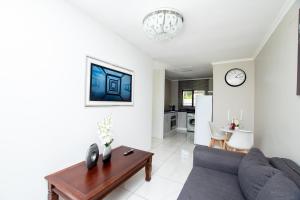 a living room with a couch and a table at Prestigious Apartments in Fourways